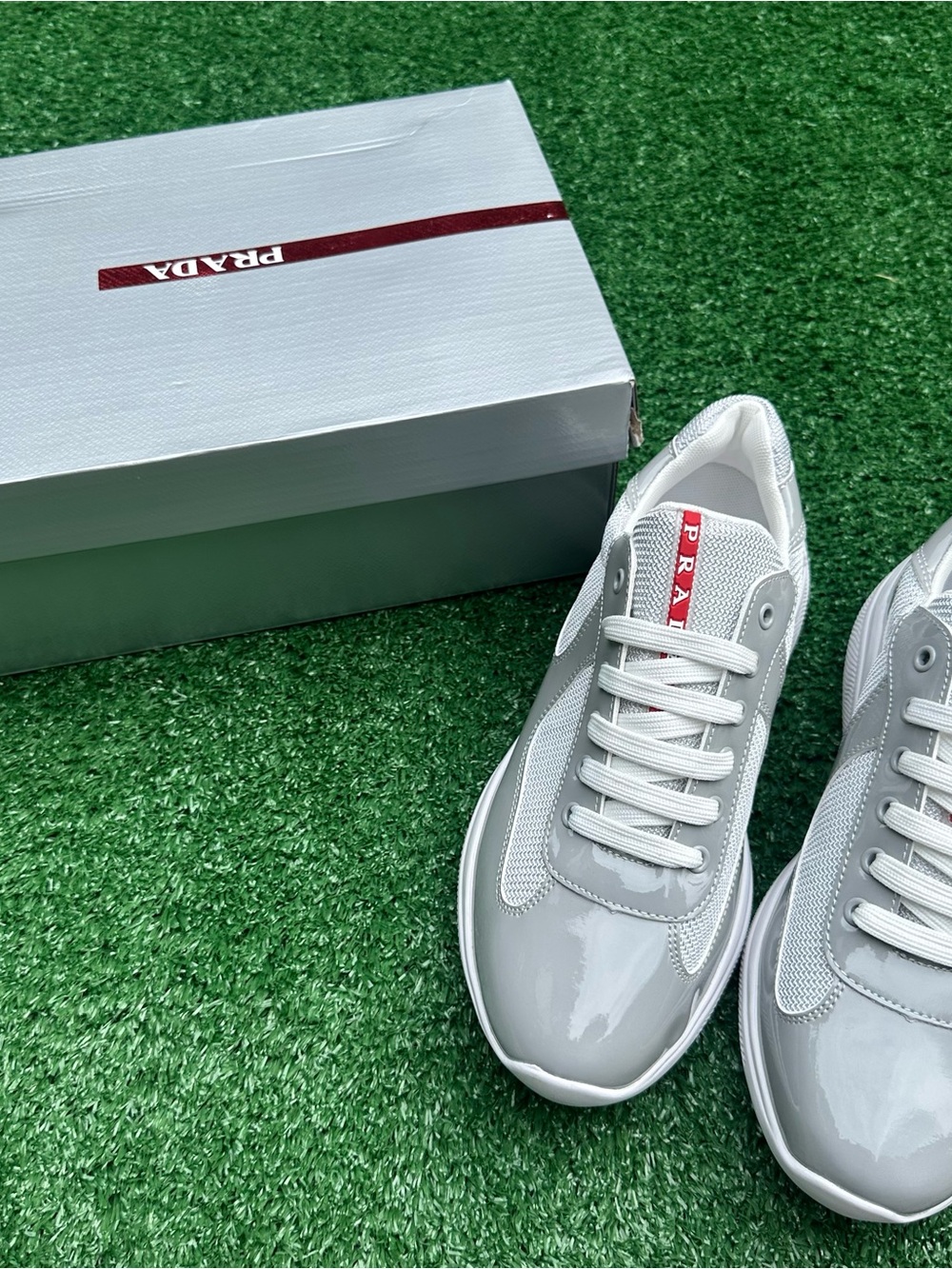 Prada White and Light Gray Low-Top Sneakers with Red Logo Tab
